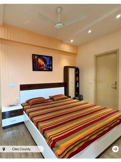 A simple and clean bedroom design in Cleo County. The combination of a white and wood-finish bed and wardrobe creates a timeless and calming space.