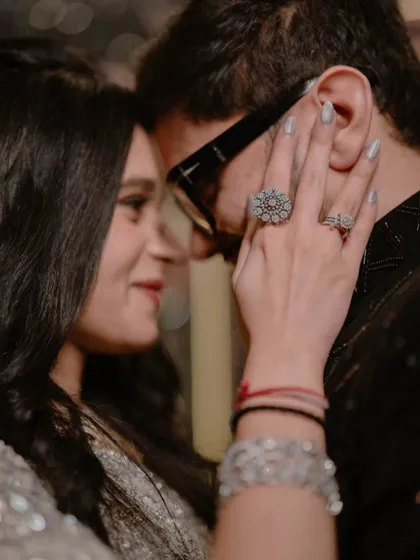 An intimate close-up, focusing on the bride's touch and their shared glance. These are the small moments that reveal the depth of a couple's connection.