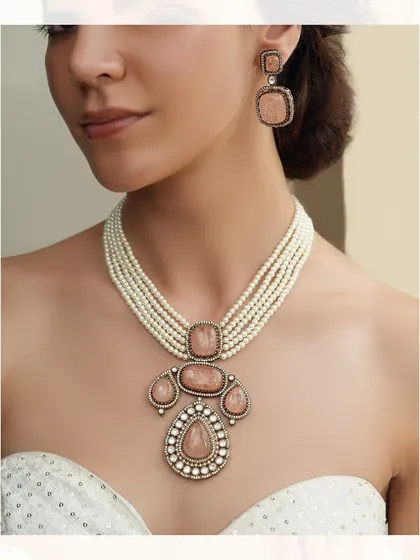 A modern classic. This necklace features a multi-strand pearl design with a unique pendant of pastel pink stones and polki.