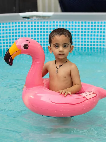 A toddler enjoys a gentle float in a pink flamingo inflatable. Our pools are perfect for kids of all ages, with options for both active play and calm floating.
