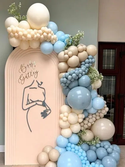 A simple yet elegant welcome sign for "Baby Gatley." The minimalist line art of a pregnant mother is a beautiful and modern touch, complemented by a soft blue and beige balloon garland.