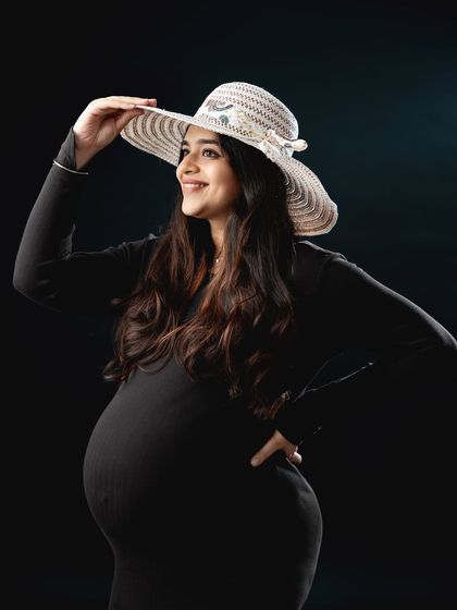 A fun and fashionable portrait with a touch of vintage charm. The addition of a sun hat gives this simple black dress photo a playful and stylish vibe.