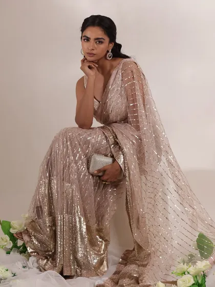 Here, I added a simple clutch to the sequined saree look. This demonstrates how the right accessory can complete an outfit, adding functionality without taking away from the glamour of the dress.