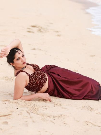 A beachside fashion shoot for a designer's modern-ethnic collection. The models are posed against the sea and coastal rocks to create a windswept, editorial feel that highlights the clothing.