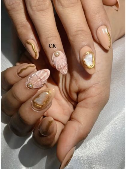A full view of my personal set, featuring nude polish with gold chrome details, 3D shells, and textured stone accents.