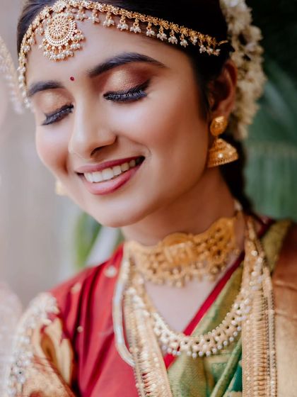 She shines when she smiles. This beautiful portrait captures the bride's joyful expression and the flawless, glowing finish of her makeup.