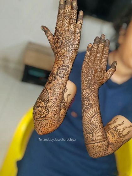 A side view of Sanaya's bridal arms, highlighting the flow of the design from the wrist up to the elbow.