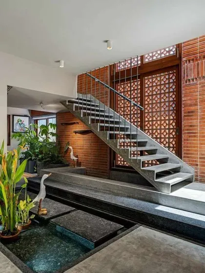 Here, I've integrated a shallow water body with stepping stones right into the home's interior design. The combination of water, stone, and plants next to the exposed brick wall creates a rich, sensory experience.