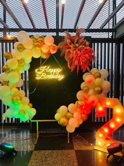 A lovely Boho-themed birthday setup. This design uses a mix of pastel and chrome balloons on a semi-arch, with dried floral arrangements and a '2' marquee number for a trendy and artistic look.