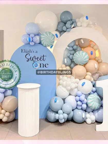 A "Sweet One" first birthday with a candy theme. The pastel blue and cream balloons, along with candy-striped accents, create a delightful and gentle look.