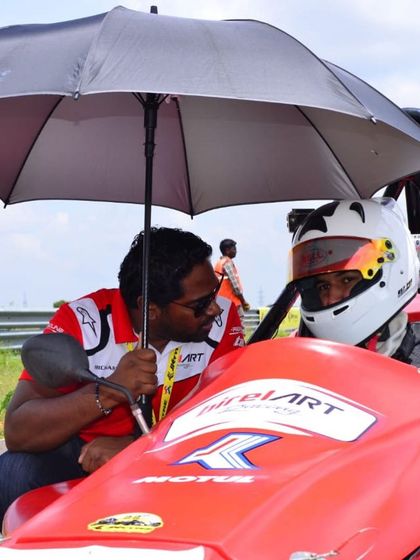 A moment of mentorship on the grid, as our coach provides last-minute instructions to our driver in the Formula LGB car.