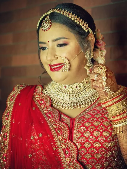 Another candid-style shot from a getting-ready session. This portrait captures the bride's happy anticipation, highlighting her smile and the beautiful traditional jewelry she is wearing.