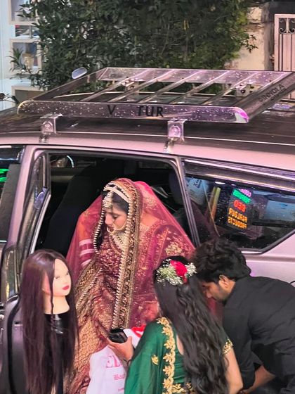 Our job doesn't end until the bride is on her way. Here we are doing final touch-ups and making sure her dupatta and lehenga are perfectly set as she gets into her car.