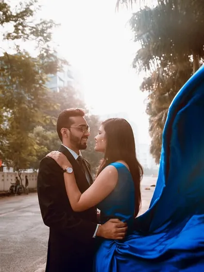 A dramatic, backlit shot on a city road. The pop of the blue gown against the urban setting creates a striking and memorable image.