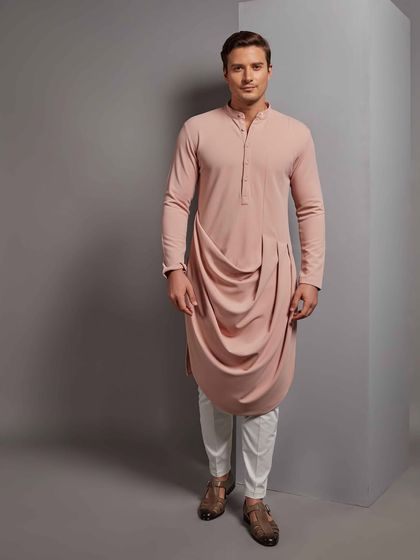 A modern twist on a classic silhouette, this draped pink kurta from The House of Govinda is for the man who isn't afraid of color or contemporary design. It's a statement piece that is both stylish and comfortable.