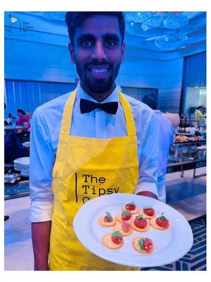 Beyond drinks, we also offer molecular appetizers. Here, our bartender presents a plate of edible spheres on crackers, a perfect example of the innovative food and beverage pairings we can create.