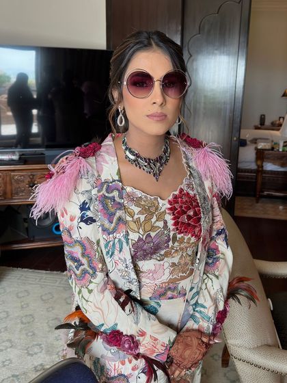 The bride channeling a cool, chic vibe with sunglasses and her unique floral ponytail.