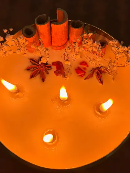 The warm glow from our multi-wick urli candle creates an inviting and festive atmosphere. The spices on top release a gentle aroma as the candle burns.
