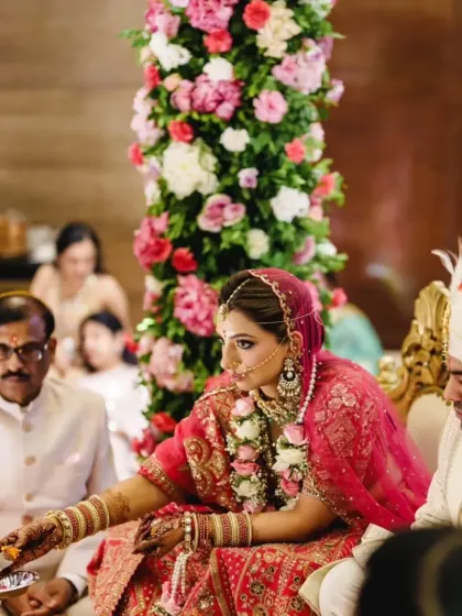A bride participates in the wedding rituals, surrounded by family and vibrant floral decor. We ensure every tradition is honored in a beautiful setting.