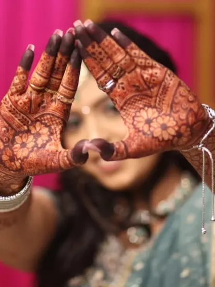 A professional photo of an engagement bride, with her beautifully stained mehendi forming a heart shape.