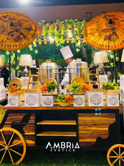 Our beautifully decorated live dim sum station, complete with traditional bamboo steamers and a chef preparing hot, steaming momos for guests at an outdoor event.