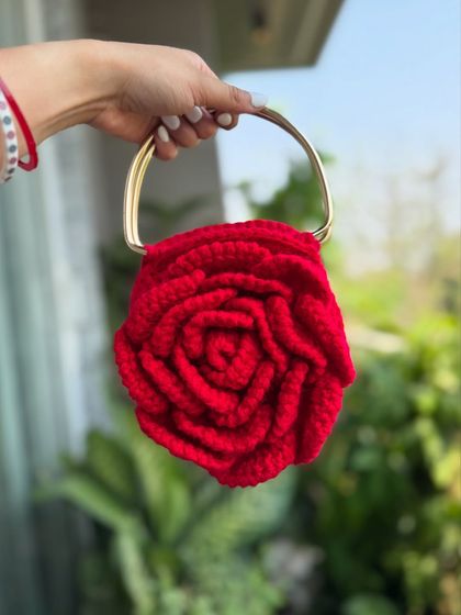 A close-up shot of our red Rose bag with a metallic handle, showcasing its vibrant color and intricate design.