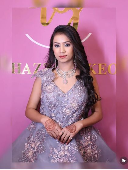 A model in a beautiful lavender-grey gown with intricate floral embroidery. The multi-layered American diamond necklace adds a touch of sophistication.
