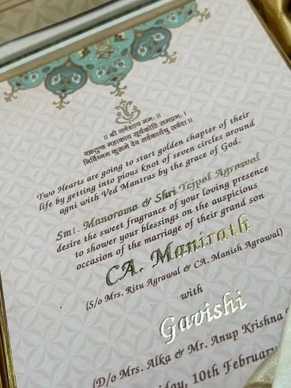 The invitation insert from the sea-green hamper, featuring elegant gold foil script and a Ganesha blessing for the auspicious occasion.