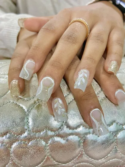 A beautiful set of clear extensions with white abstract line work and leaf patterns. The translucent effect gives these nails a delicate, almost ethereal quality.