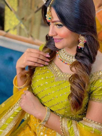 A smiling, happy client showing off her festive makeup and hairstyle.