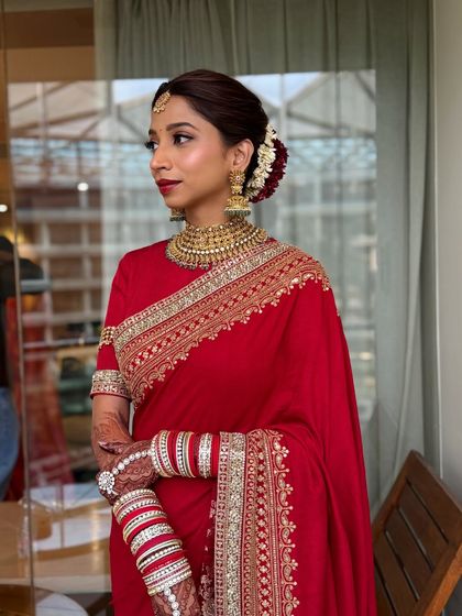 Another angle of the timeless South Indian bride. The hair is styled in a traditional bun with flowers, complementing the classic makeup.