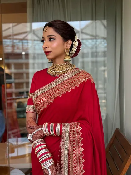 Another angle of the timeless South Indian bride. The hair is styled in a traditional bun with flowers, complementing the classic makeup.