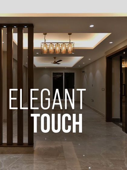 An elegant touch is added with this wooden partition, which separates spaces while maintaining an open feel. The combination of the partition, tray ceiling, and modern chandelier creates a sophisticated entryway.