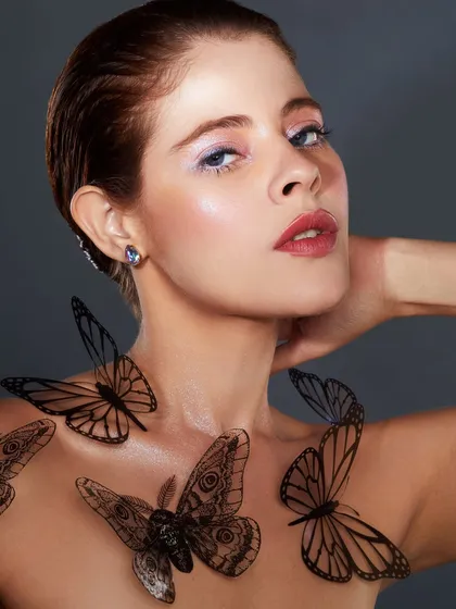 A delicate and whimsical look with a soft wash of color on the eyes and beautiful butterfly appliques on the body.