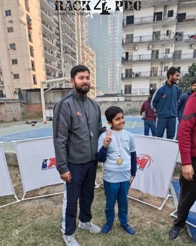 A proud coach stands with one of our U-8 medal winners. The bond between our coaches and players is fundamental to building both skills and character.