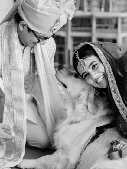 A wedding isn't complete without the four-legged family members. A heartwarming black and white moment as the bride and groom share a special cuddle with their golden retriever.