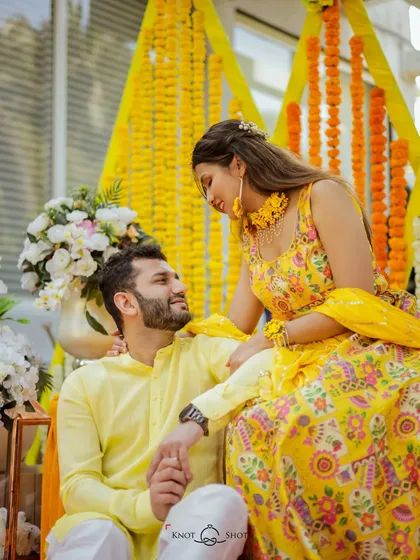 A sweet portrait of the couple during their haldi. The bride sitting on the groom's lap is a playful and affectionate pose.