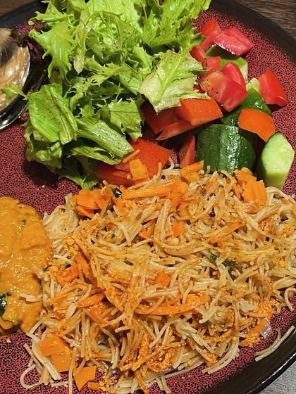 A plate of vegetable seviyan (vermicelli) with a side salad and a flavorful peanut chutney. A tasty and balanced meal.