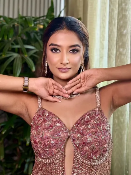 A playful and confident pose. The makeup enhances her features and gives her a star-like quality.