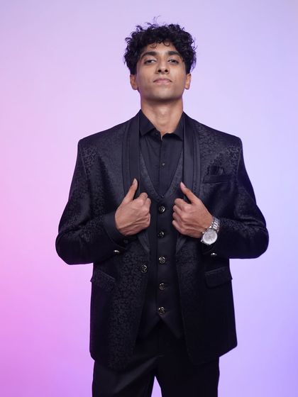 A close-up of the black jacquard tuxedo, showing the subtle pattern and the sharp cut of the jacket.