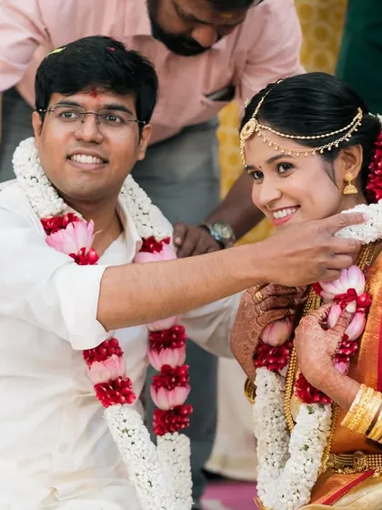 A happy moment during the garland exchange at a South Indian wedding.