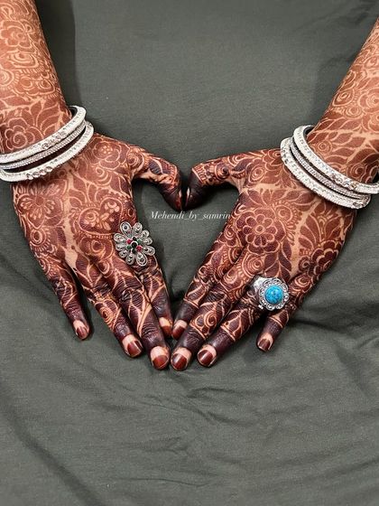 A heart pose showing off the beautiful, mature henna stain. The dark color makes the floral patterns look so rich and elegant, perfect for capturing memories.