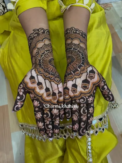 A full view of this stunning mandala and 'jhumka' design. The client's bright yellow outfit makes the dark henna stain pop beautifully.