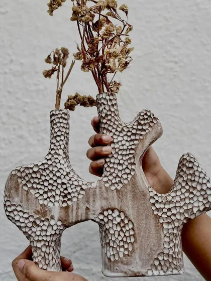 This sculptural vase is what happens when our hand-building artists get to play. The intricate carving and organic shape make it a true statement piece for any space, with or without flowers.