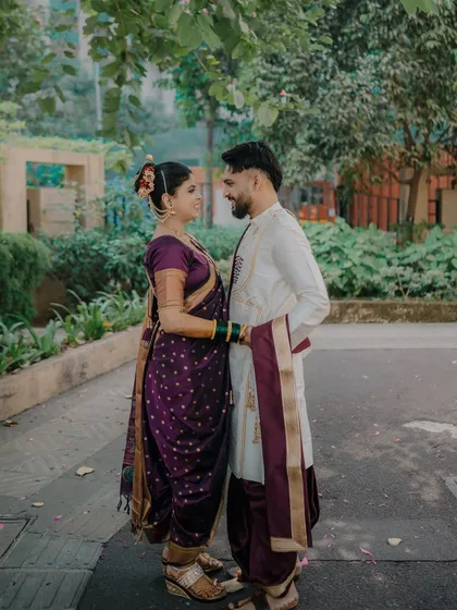 A full-length shot of the couple sharing a happy, interactive moment. This image captures their dynamic and joyful relationship against a natural, green background.