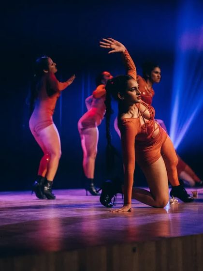 The vibrant red costumes and dramatic lighting add to the theatricality of our Heels performance piece.