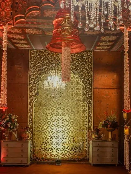 This entrance was designed to feel sacred and royal, framed with golden jaalis and Mughal arches, and adorned with cascading floral bells and glistening chandeliers.
