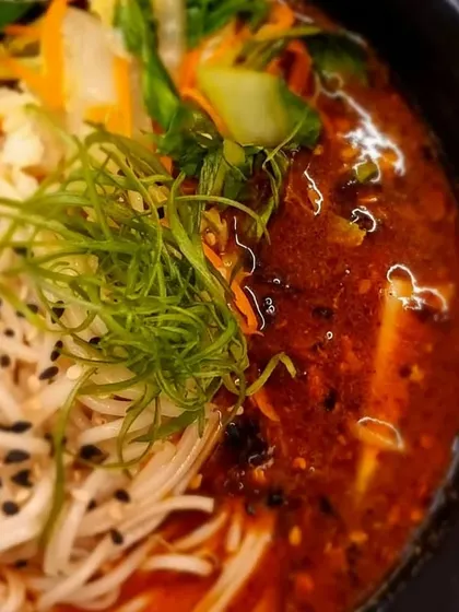 A close-up of a flavourful Asian noodle soup. We make our broths and curries from scratch, and our Khao Suey is one of the best in the city.