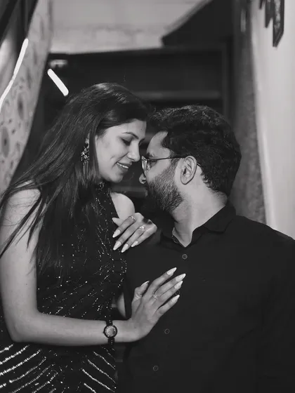 A classic black and white portrait, capturing an intimate and romantic moment on a staircase.