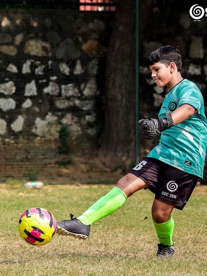 A young GSC goalkeeper kicks the ball upfield, demonstrating good technique.